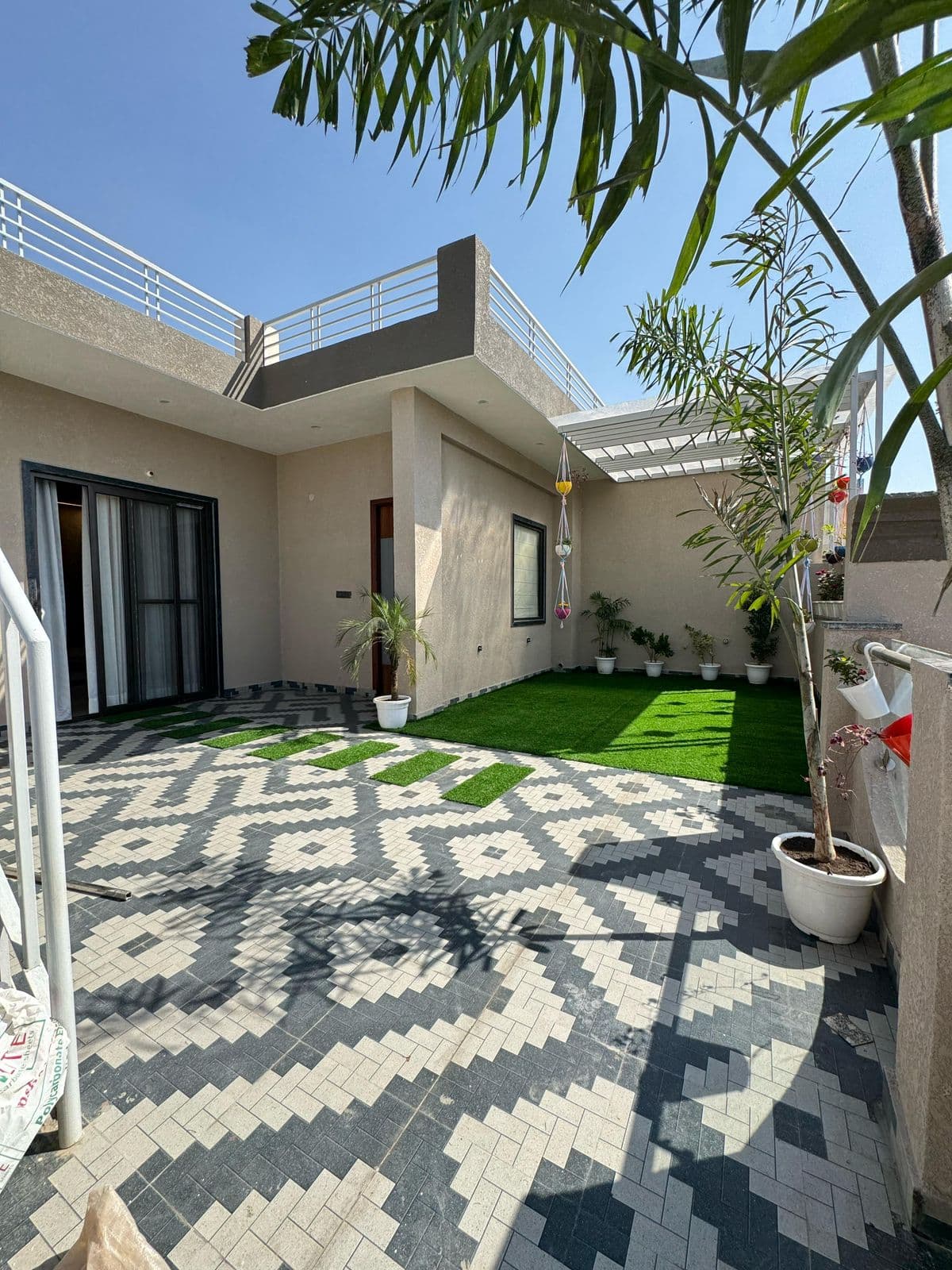 Modern courtyard with patterned tiles & artificial grass
