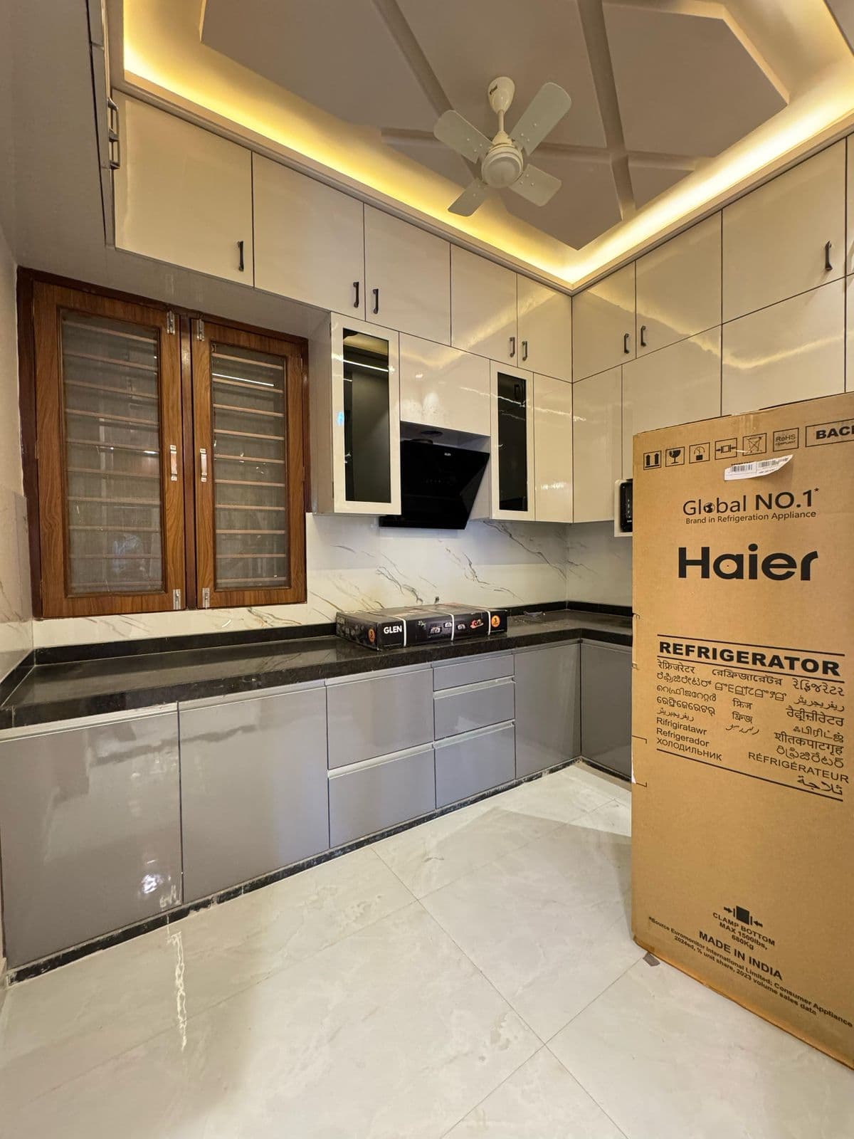 L-shaped modular kitchen with false ceiling lighting