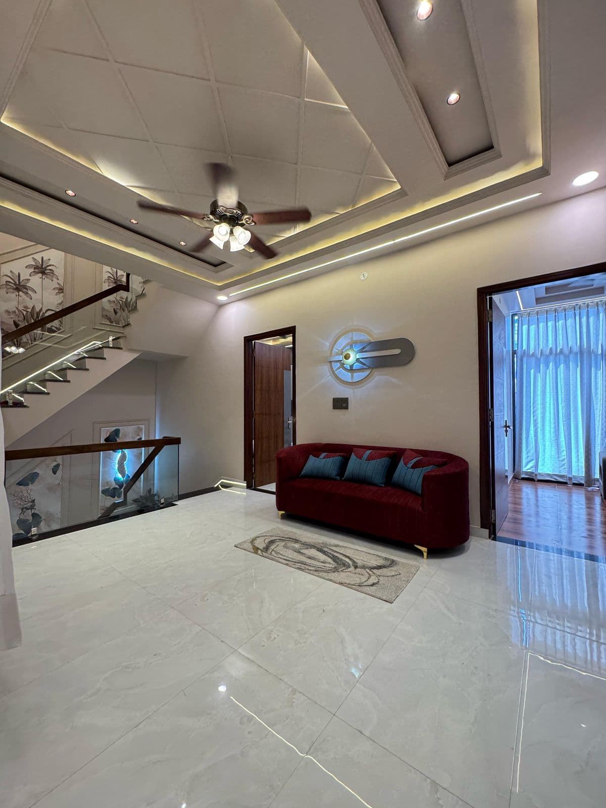 Living room with staircase, sofa & glass railing